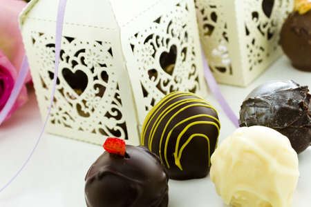 Square white decorative lace heart favor boxes filled with gourmet truffles.の写真素材