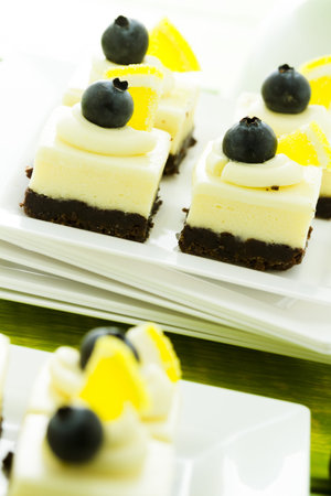 Small white chocolate cheesecake squares at dessert bar.の写真素材
