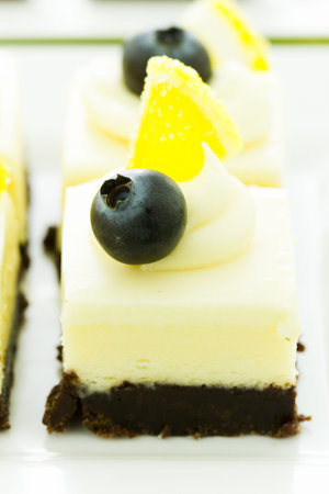 Small white chocolate cheesecake squares at dessert bar.の写真素材