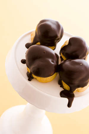 Cream puffs dipped in chocolate at desert bar.の写真素材