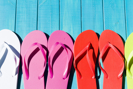 Colorful flip flops by a swimming pool.の写真素材