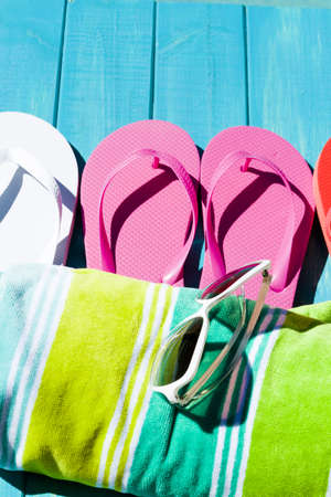 Colorful flip flops by a swimming pool.の写真素材