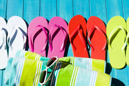 Colorful flip flops by a swimming pool.の写真素材
