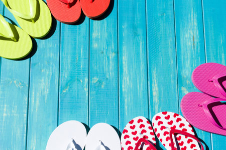 Colorful flip flops by a swimming pool.