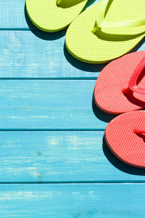 Colorful flip flops by a swimming pool.の写真素材