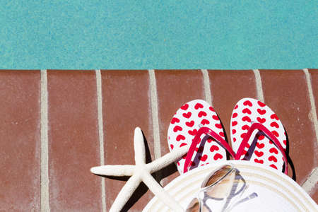 Colorful flip flops by a swimming pool.の写真素材