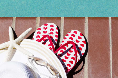 Colorful flip flops by a swimming pool.の写真素材