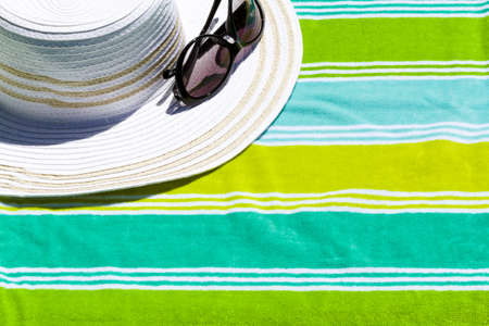 Summer hat with sunglasses on a beach towel.の写真素材