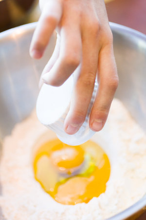 Mixing dough for cookies in a large metal bowl.