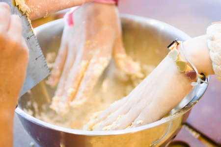 Mixing dough for cookies in a large metal bowl.の写真素材