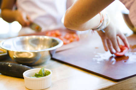 Kinds in cooking class making bruschetta.の写真素材