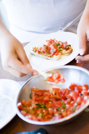 Kinds in cooking class making bruschetta.の写真素材