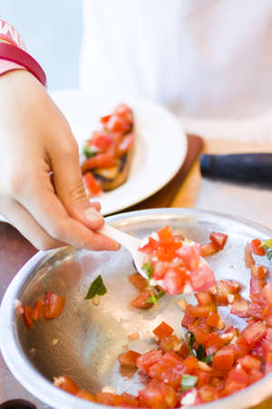 Kinds in cooking class making bruschetta.の写真素材