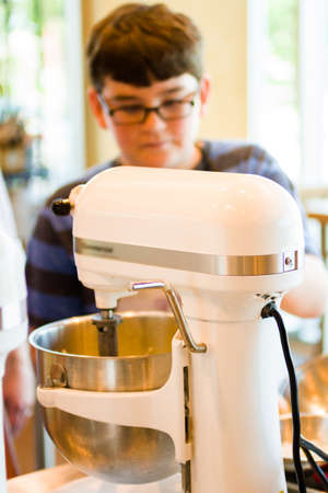 Kid in cooking class learning how to cook and bake.の写真素材