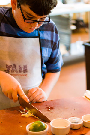 Kids in cooking class learning how to cook and bake.の写真素材