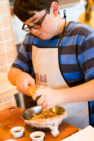 Kids in cooking class learning how to cook and bake.の写真素材