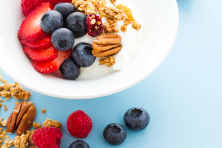 Parfait with fresh fruits and granola in white bowl.の写真素材