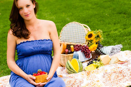 Pregnant woman having a picnic in the park.の写真素材