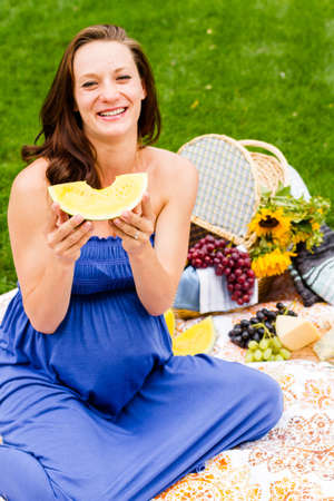 Pregnant woman having a picnic in the park.の写真素材