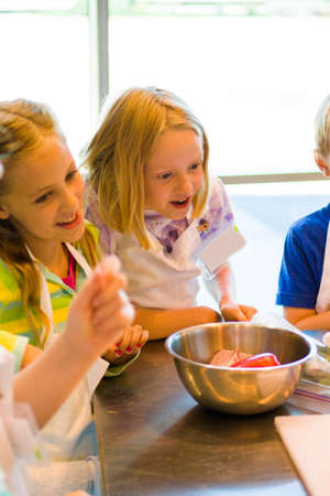 Kids learning how to cook in a cooking class.の写真素材