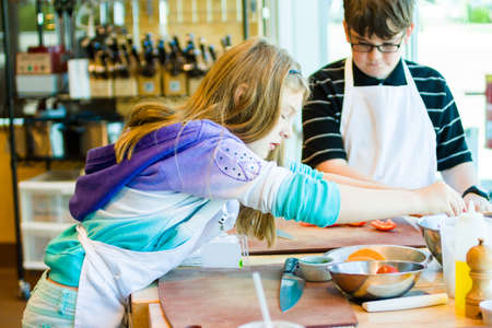 Kids learning how to cook in a cooking class.の写真素材