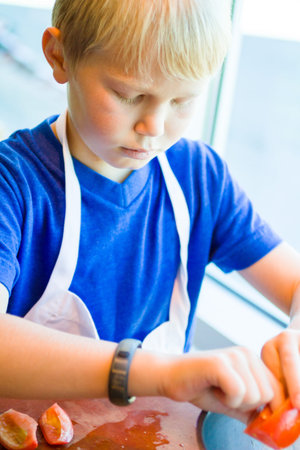 Kids learning how to cook in a cooking class.の写真素材