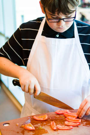 Kids learning how to cook in a cooking class.の写真素材