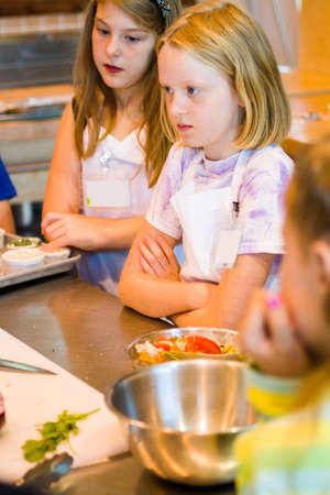 Kids learning how to cook in a cooking class.の写真素材
