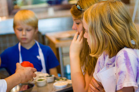 Kids learning how to cook in a cooking class.の写真素材