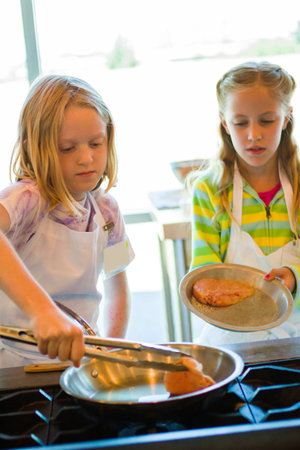 Kids learning how to cook in a cooking class.の写真素材