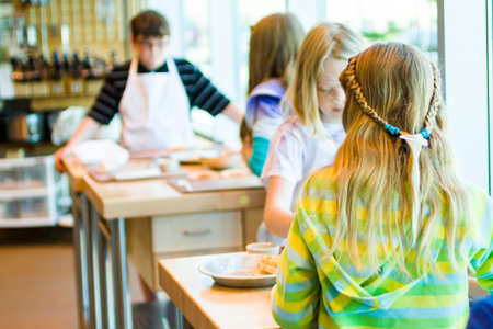 Kids learning how to cook in a cooking class.の写真素材
