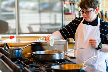 Kids learning how to cook in a cooking class.の写真素材