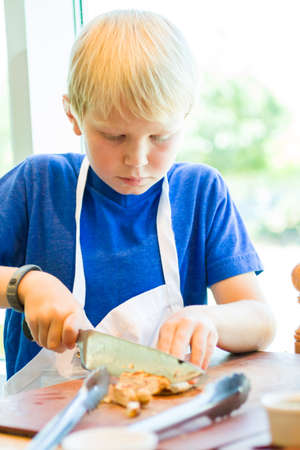 Kids learning how to cook in a cooking class.の写真素材