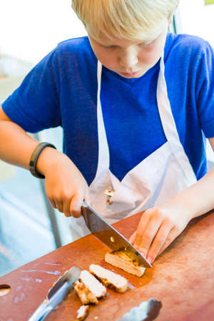 Kids learning how to cook in a cooking class.の写真素材