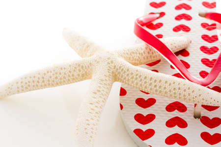 Star sea shell with flip flops on a white background.の写真素材