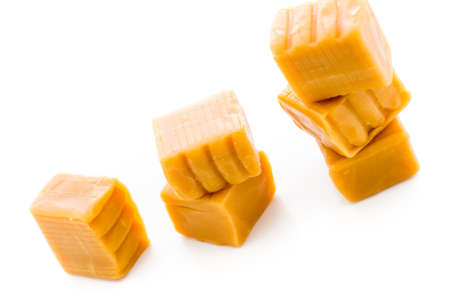 Vanilla caramel candy unwrapped on a white background.の写真素材