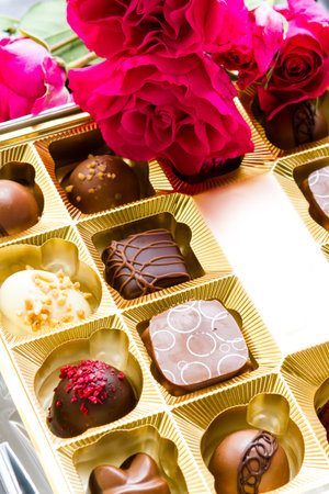 Gift box of assorted gourmet chocolate truffles on silver silk.
