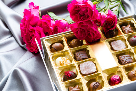 Gift box of assorted gourmet chocolate truffles on silver silk.