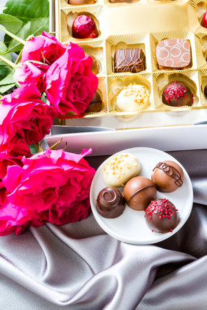 Gift box of assorted gourmet chocolate truffles on silver silk.