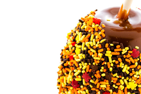 Hand dipped caramel apple covered with multi color sprinkles.の写真素材