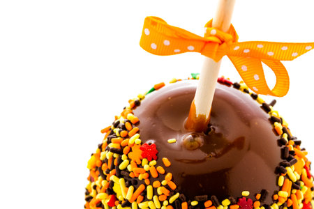 Hand dipped caramel apple covered with multi color sprinkles.の写真素材