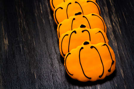 Sugar cookies with orange icing shaped like a pumpkin.の写真素材