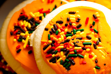 Sugar cookies with orange icing and spkinkles.