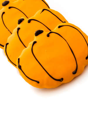 Sugar cookies with orange icing shaped like a pumpkin.の写真素材