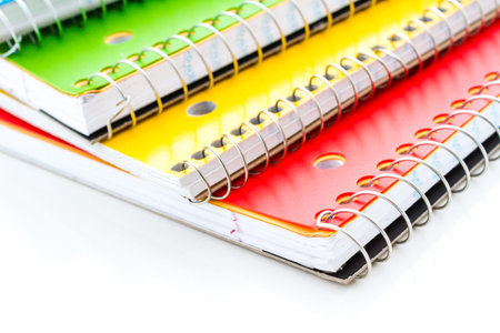 Multicolored spiral notebooks on a white background.