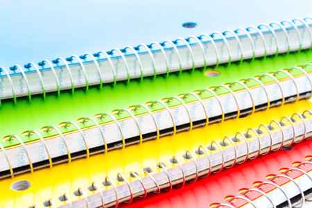 Multicolored spiral notebooks on a white background.