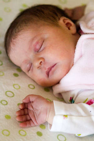 Newborn baby girl sleeping in her crib.の写真素材
