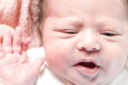 Newborn baby girl playing on pink blanket.の写真素材