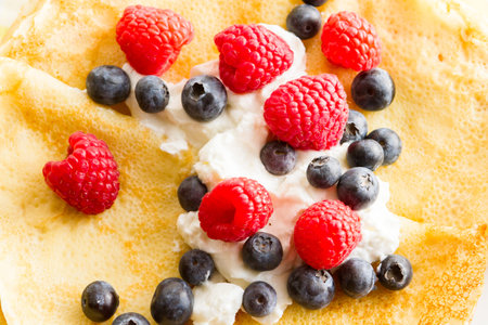 Homemade crepes with fresh raspberries and blueberries.の写真素材