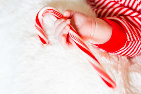 Newborn Christmas baby girl in elf hat on a white blanket.の写真素材